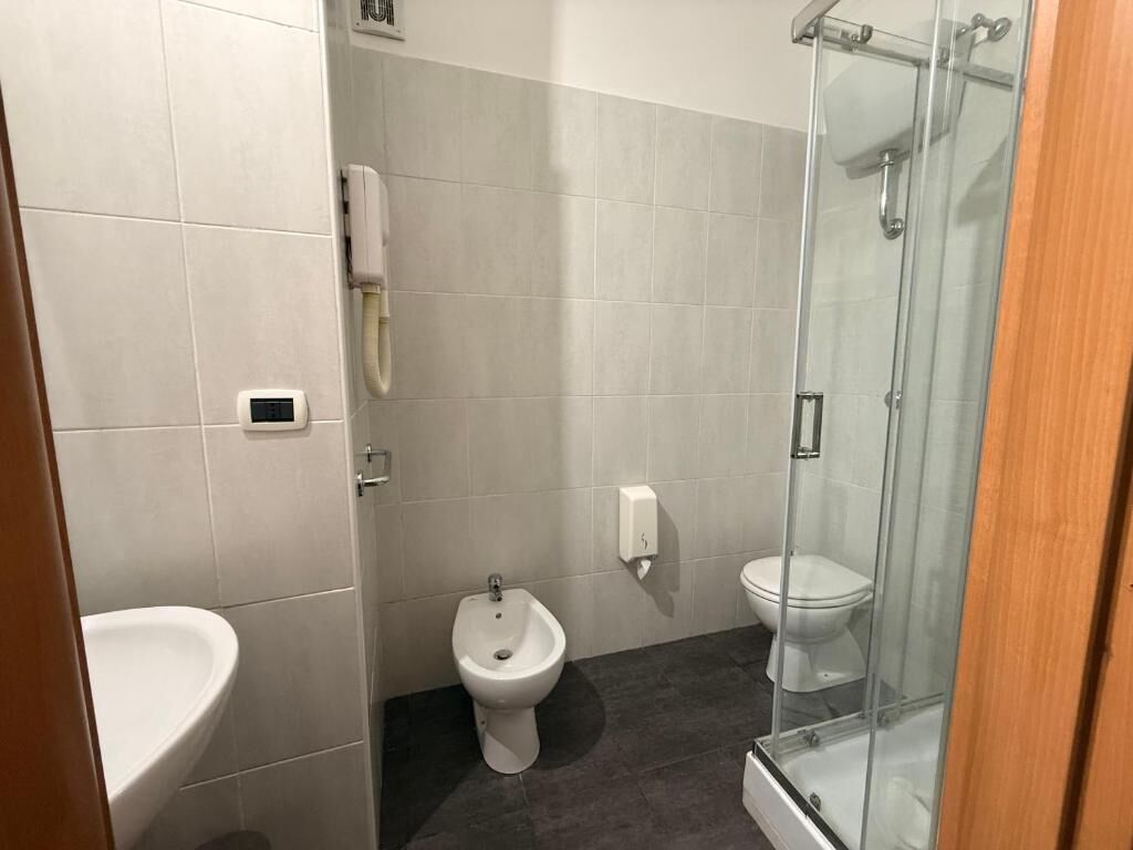 A bathroom with a bidet, toilet, and sink.