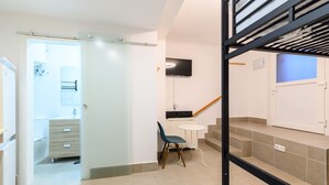 Un interior modern amb una escala, una taula petita i una cadira.
