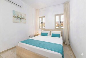 A bedroom with a bed, a window, a painting, and a nightstand. - 4 bedroom villa by Fig tree bay beach (Protaras)