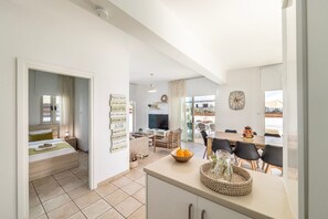 Een moderne leefruimte met keuken, eethoek en slaapkamer, compleet met een groot bed en televisie.