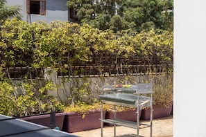 A rooftop garden with a metal table and potted plants. - 4 bedroom villa by Fig tree bay beach (Protaras)