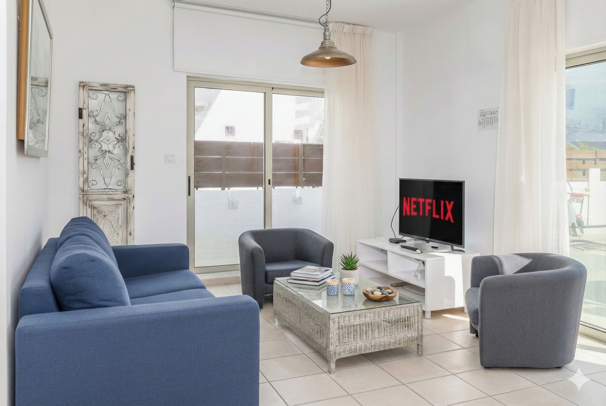 Ett modernt vardagsrum med en soffa, fåtöljer, ett soffbord och en tv som visar Netflix.