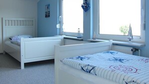 Et soveværelse med to enkeltsenge, et vindue og en radiator.
