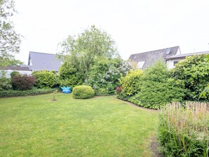 A well-maintained garden with various shrubs and a lawn.