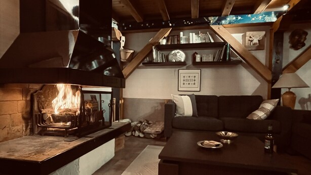 A cozy living room with a fireplace, a sofa, a coffee table, and a bookshelf. - Large triplex at the foot of the slopes ideal for two families (Morillon)