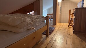 A bedroom with a wooden bed, a wooden dresser, and a small wooden table. - Large triplex at the foot of the slopes ideal for two families (Morillon)
