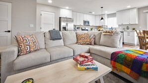 Ein modernes Wohnzimmer mit einer Couch, einem Couchtisch und einer farbenfrohen Decke.