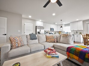 A modern living room with a sofa, coffee table, and a colorful quilt. - New 2025 Modern Home, Ice-Cold A/C, 8 Min to Sky Harbor, Sleeps 6 (Phoenix)