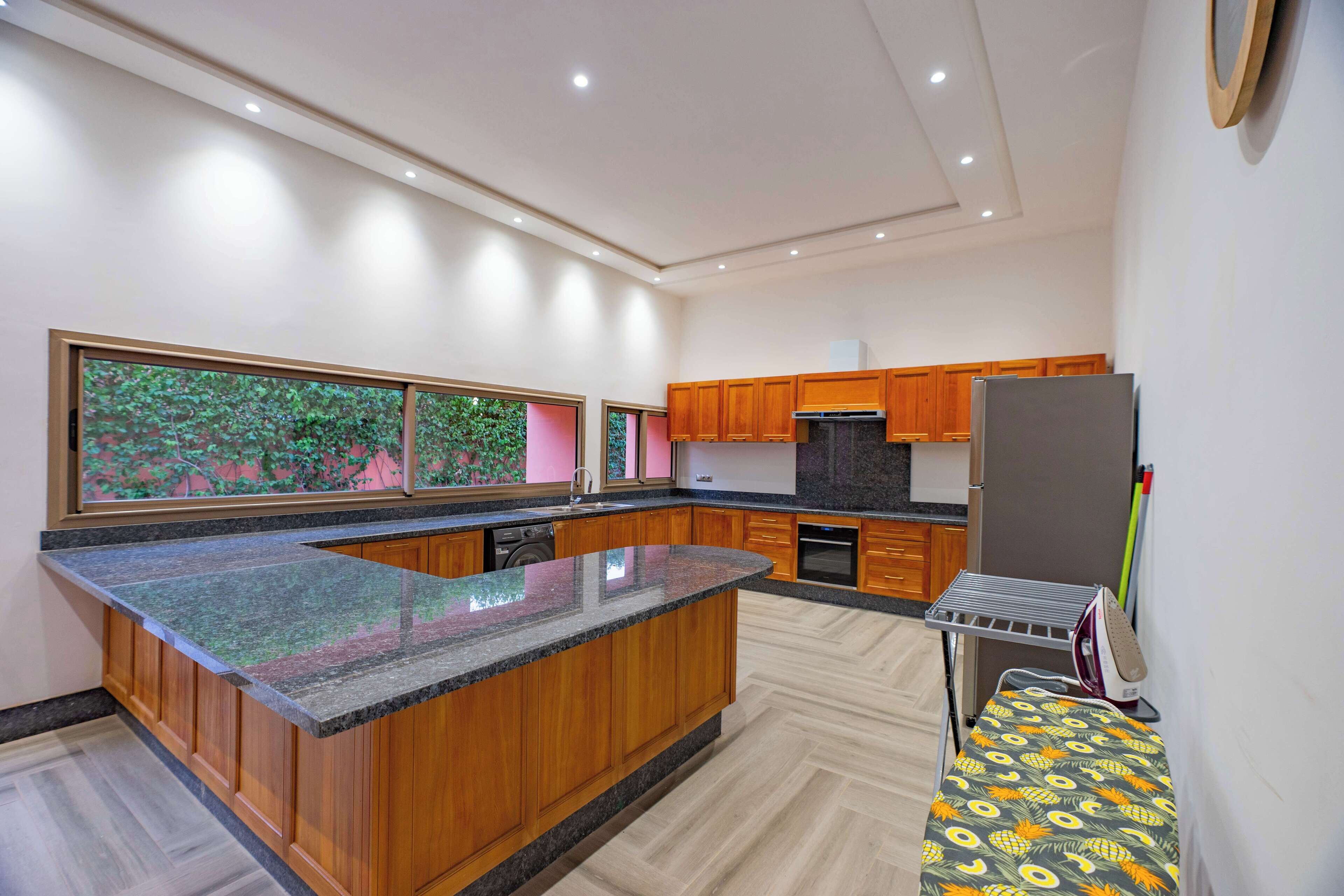 A modern kitchen with wooden cabinets, granite countertops, and a built-in oven.