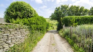 A rural dirt path flanked by stone walls and wooden fences, leading to a green landscape. - Sloopside - Bantham, South Devon (Bantham)