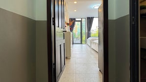 A hotel hallway leading to a living room with a view of the outside. - Came House - Near Bui Vien street (Ho Chi Minh City)