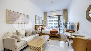 Uma sala de estar moderna com sofá, mesa de centro e área de jantar.