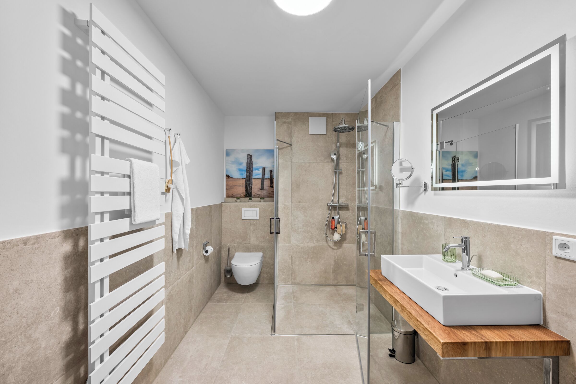 Een moderne badkamer met douche, toilet en wastafel.