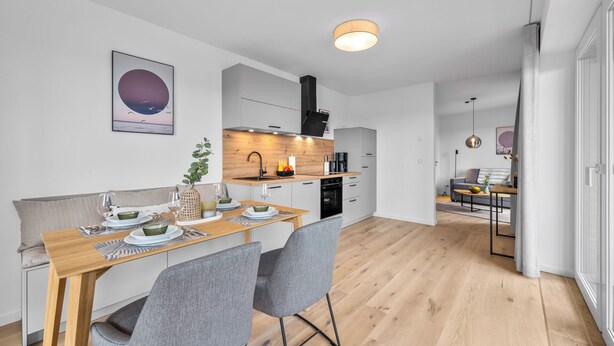 A modern kitchen with a wooden countertop, integrated appliances, and a view into the dining area. - The View B08 Kapitänskajüte - Elevator, shared Sauna, underfloor heating,balcony (Dagebüll)