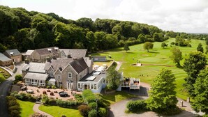 Un vaste domaine comprenant une maison principale, plusieurs chambres d’hôtes et une pelouse bien entretenue, ainsi qu’un terrain de golf.