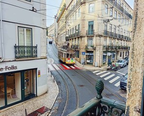 A tram on a street with buildings on either side. - S o Bento Tramview Residence (Lisbon)