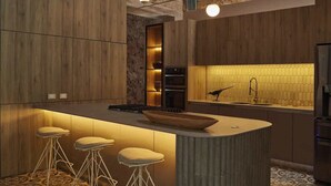 A modern kitchen with a central island, bar stools, and a patterned floor. - NOK Luxury Colonial Villa 6BR With Pool Staff Breakfast at Getsemani (Cartagena)