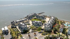 Un quartier résidentiel situé sur la côte, composé de plusieurs maisons à deux étages, doté d’une cour centrale et offrant une vue sur l’océan.