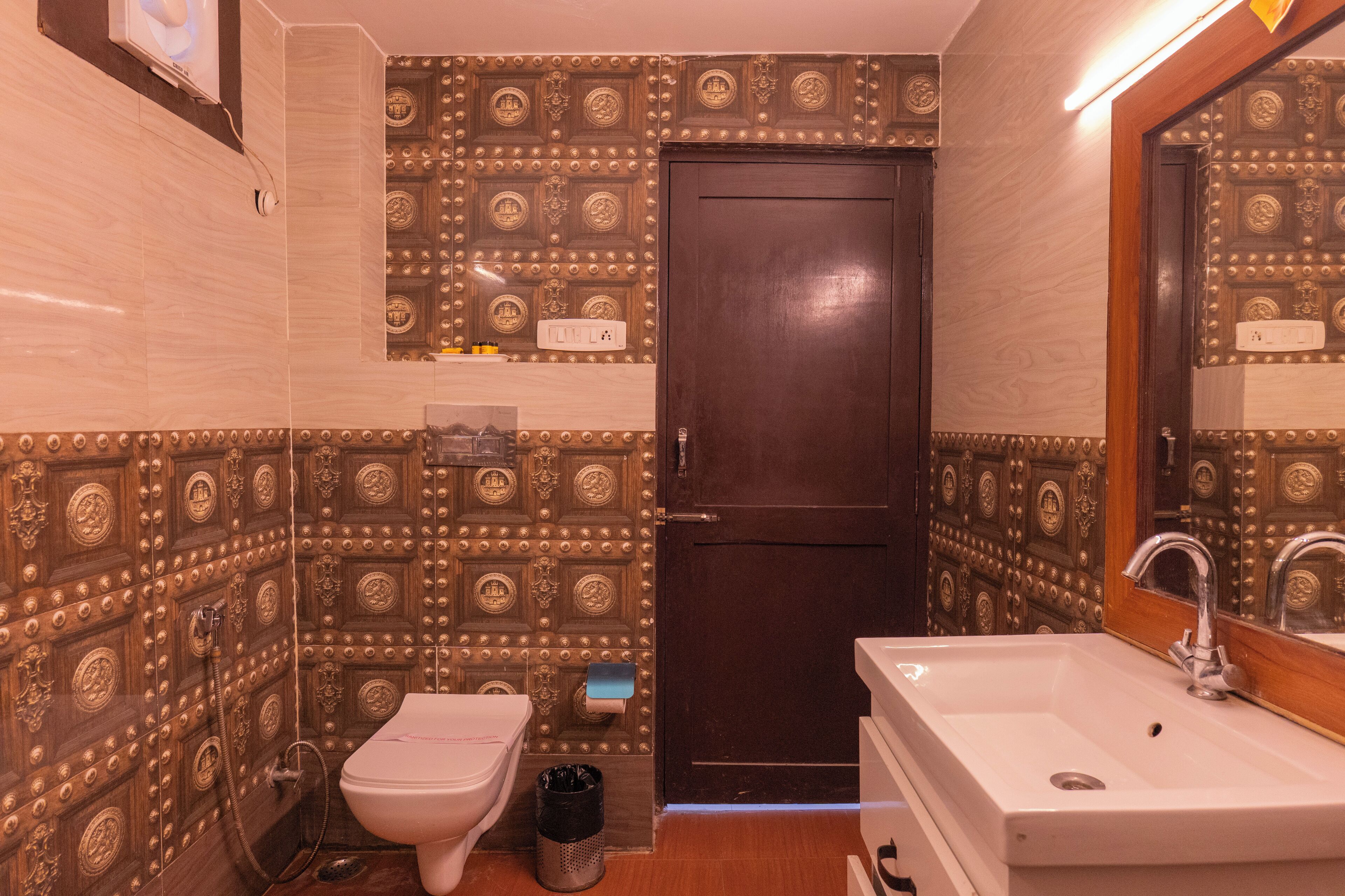 A bathroom with a toilet, sink, and a door with decorative panels.