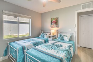 A bedroom with two beds, a window, a painting, and a door. - Canal-front Oasis! Port Charlotte Condo w/ Lanai (Port Charlotte)