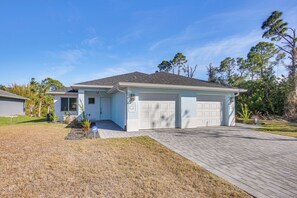 A single-story house with a garage, a paved driveway, and a small lawn. - Canal-front Oasis! Port Charlotte Condo w/ Lanai (Port Charlotte)
