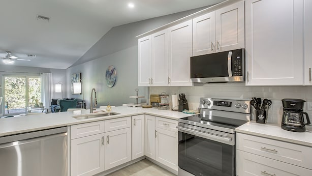 A modern kitchen with white cabinets, stainless steel appliances, and a large window. - Canal-front Oasis! Port Charlotte Condo w/ Lanai (Port Charlotte)
