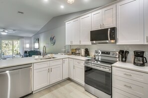A modern kitchen with white cabinets, stainless steel appliances, and a large window. - Canal-front Oasis! Port Charlotte Condo w/ Lanai (Port Charlotte)