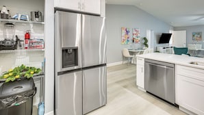 A modern kitchen with stainless steel appliances, a dishwasher, and a dining area with a table and chairs. - Canal-front Oasis! Port Charlotte Condo w/ Lanai (Port Charlotte)