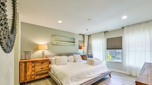 A bedroom with a large bed, wooden dresser, and a window with curtains. - 1 Mi to Beach! San Clemente Gem w/ Rooftop Patios (San Clemente)