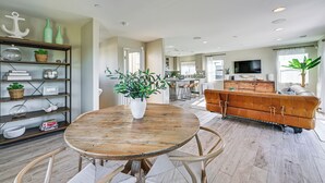 A spacious living room with a round wooden table, a brown leather sofa, and a kitchen in the background. - 1 Mi to Beach! San Clemente Gem w/ Rooftop Patios (San Clemente)