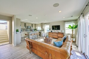 A spacious living area with a leather sofa, a wooden coffee table, and a TV mounted on the wall. - 1 Mi to Beach! San Clemente Gem w/ Rooftop Patios (San Clemente)