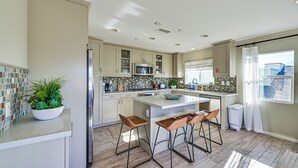 A modern kitchen with a central island, bar stools, and a potted plant. - 1 Mi to Beach! San Clemente Gem w/ Rooftop Patios (San Clemente)