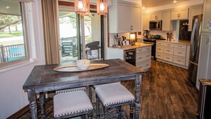 A modern kitchen with dark wood cabinetry, a central island with seating, and a view to the outside. - 2 Mi to Winter Park & Alto Lake! Family Retreat (Alto)