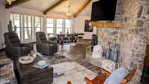 A spacious living area with a stone fireplace, leather sofas, and a dining table with chairs. - 2 Mi to Winter Park & Alto Lake! Family Retreat (Alto)