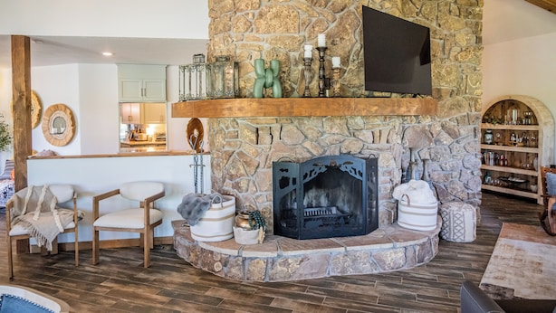 A stone fireplace with a TV above it, surrounded by seating and decorative items. - 2 Mi to Winter Park & Alto Lake! Family Retreat (Alto)
