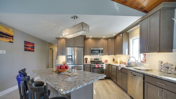 A modern kitchen with granite countertops, stainless steel appliances, and wooden cabinets. - 3 Blocks to Lake George Village: Spacious Home! (Lake George)