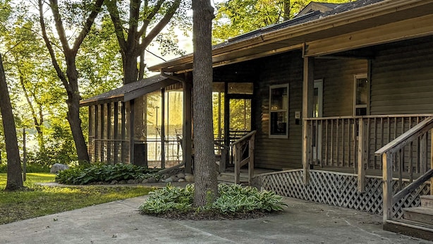 Eine Holzhütte mit Veranda, Treppe und einem kleinen Garten.