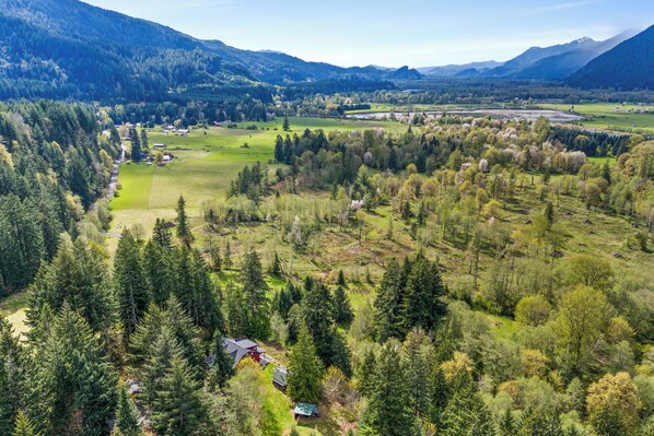 A mountainous landscape with a river, forested areas, and a small settlement with houses. - Skiing Or Hiking: Perfect Location! (Packwood)