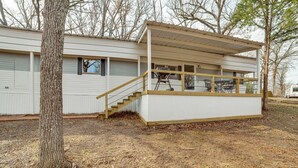 Ein Bungalow mit überdachter Veranda und einer kleinen Treppe zum Eingang.