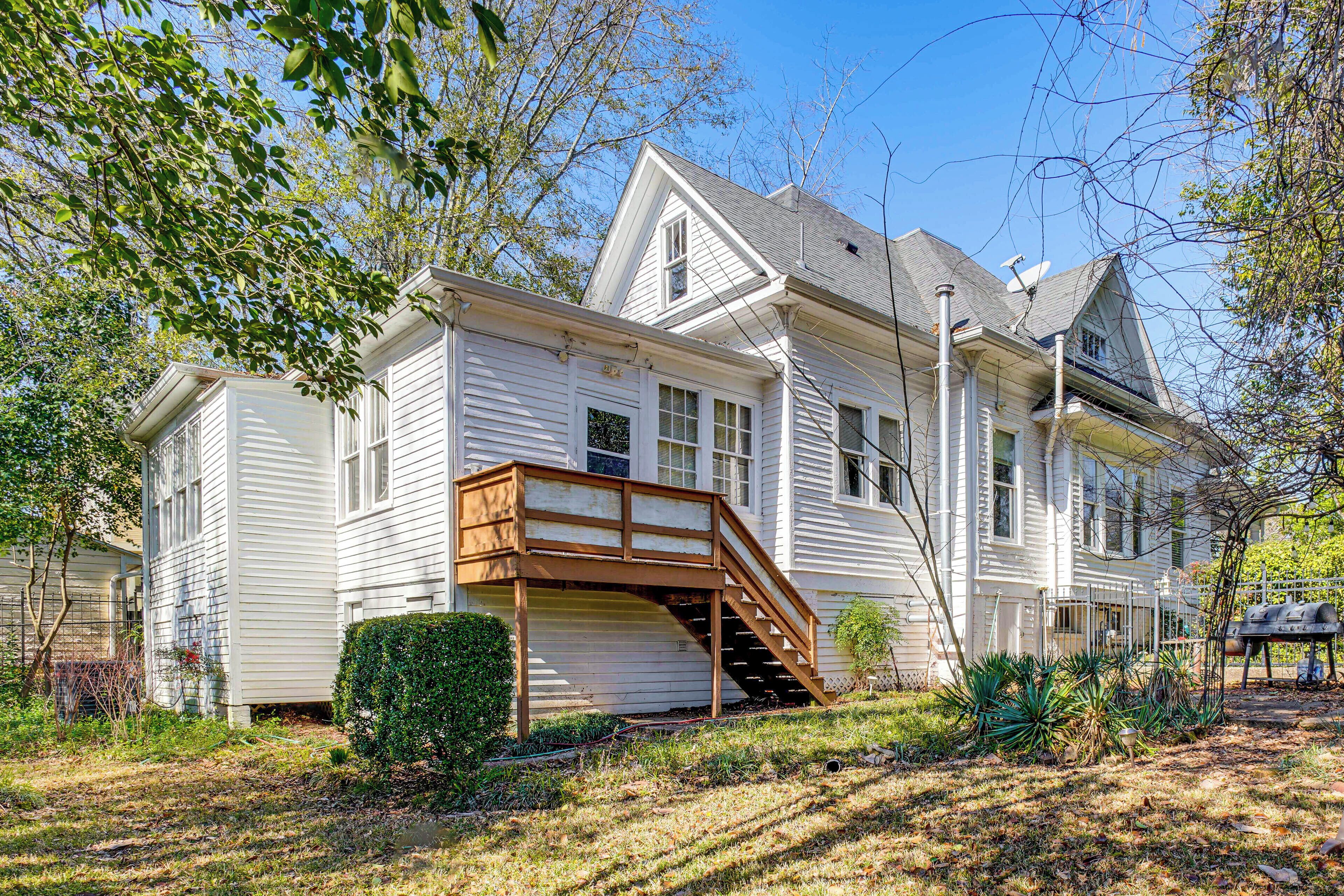 A two-story house with a covered front porch and a staircase leading to the second floor.