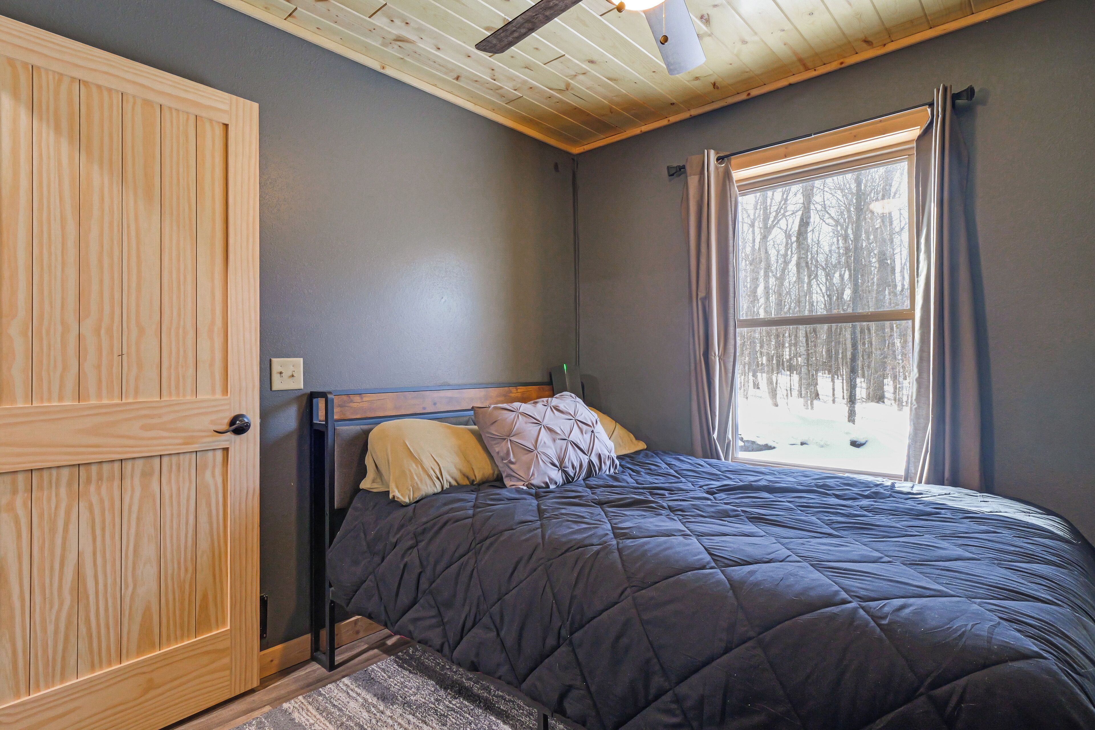 Une chambre à coucher avec un lit, une armoire en bois et une fenêtre avec des rideaux.