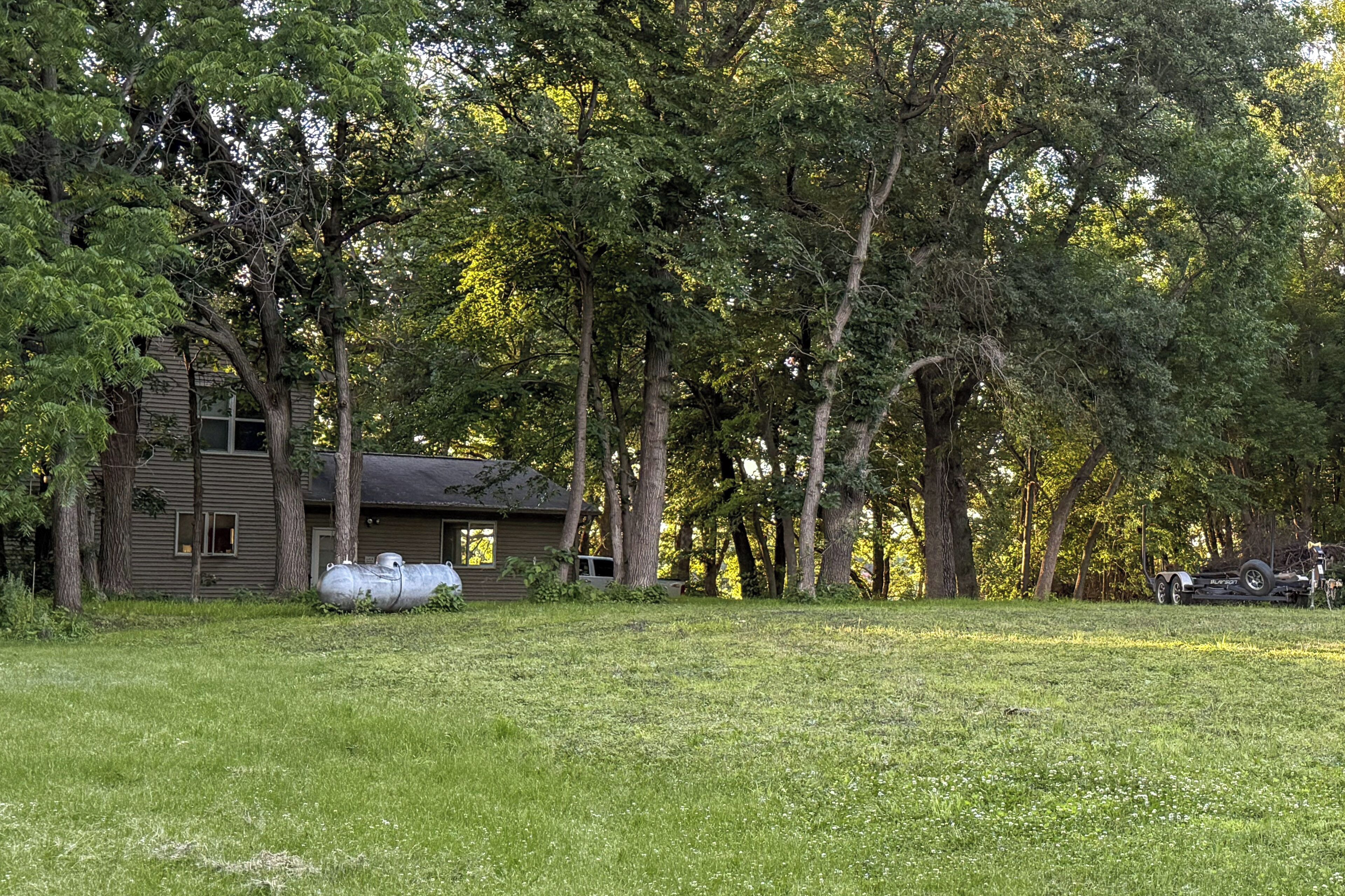 A house surrounded by trees with a grassy yard.