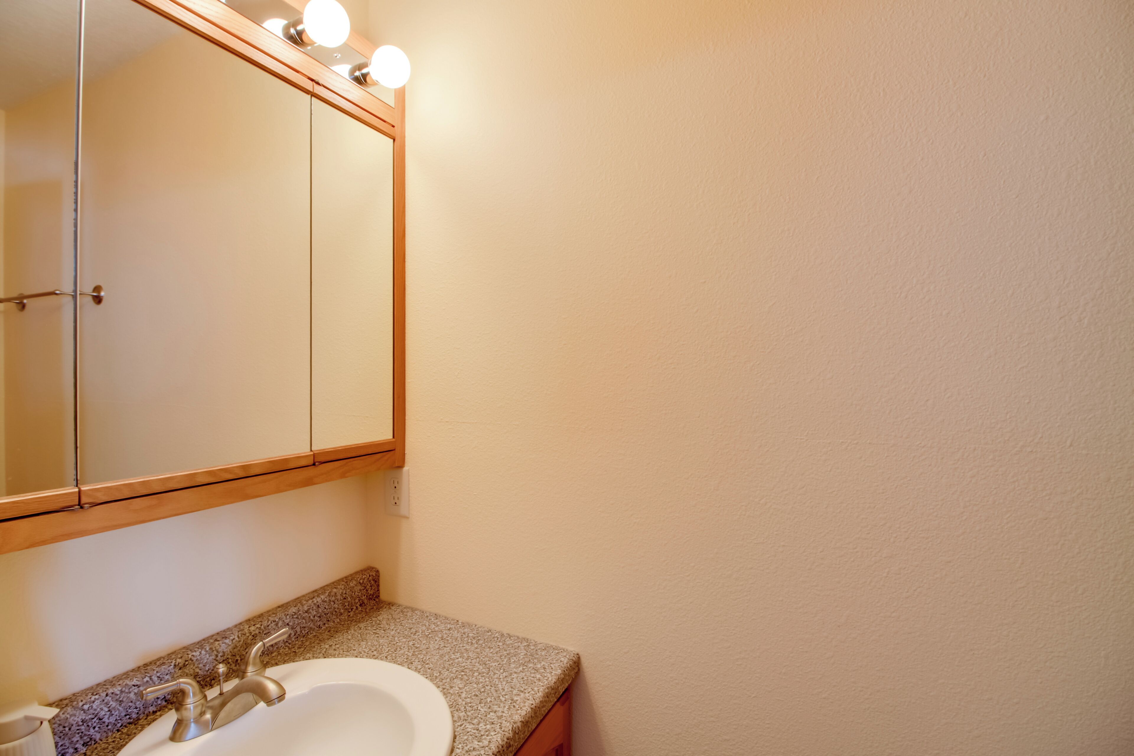 Une salle de bain avec un lavabo, un miroir et un meuble-lavabo.