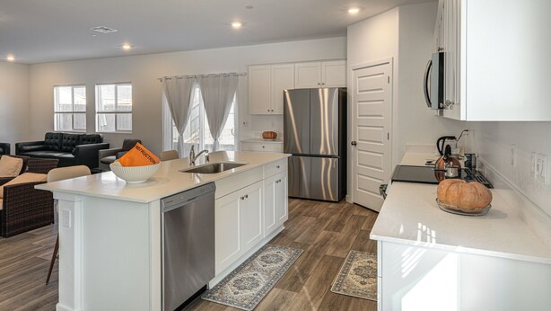 A modern kitchen with white cabinetry, stainless steel appliances, and a central island. - Pet-friendly Yard! Family Home in Bakersfield (Bakersfield)