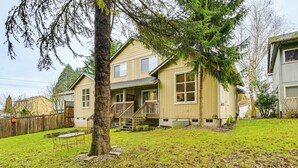 A two-story house with a front porch, a staircase, and a fenced backyard. - Mcm-inspired Decor & Top Location! Tumwater Duplex (Olympia)
