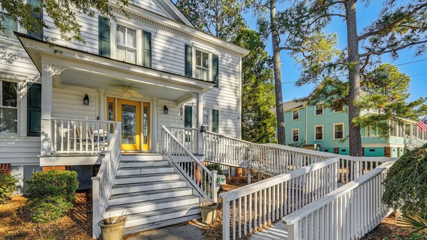 A two-story white house with a front porch, a staircase, and a white fence. - Timeless Charm! Family Home Near Belhaven Beach (Belhaven)