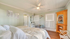 A bedroom with a large bed, a ceiling fan, a dresser, and a mirror. - Timeless Charm! Family Home Near Belhaven Beach (Belhaven)