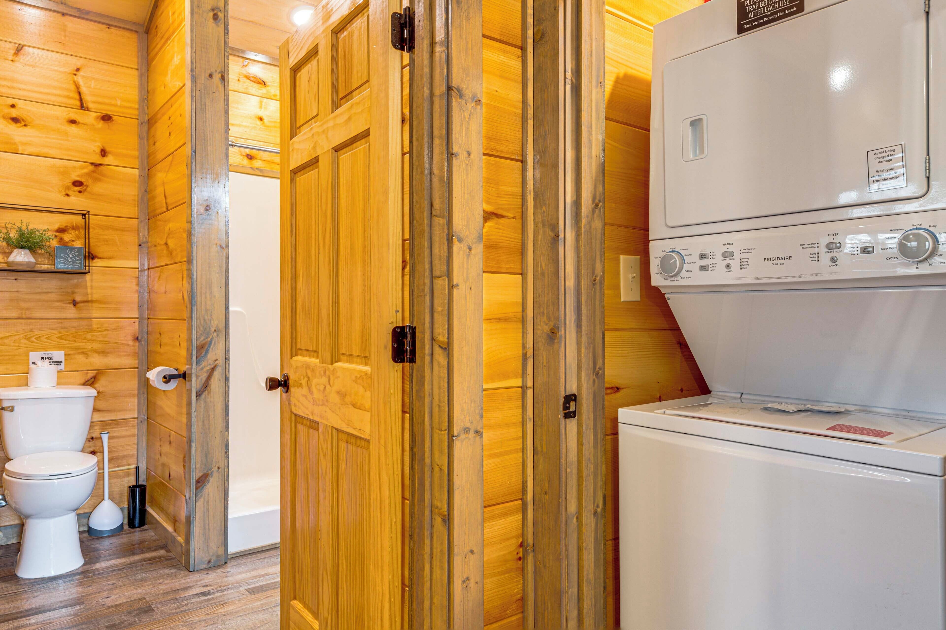 A wooden interior with a white washing machine and a toilet.