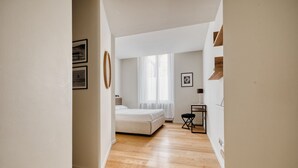 Een slaapkamer met een bed, een bureau en een stoel.