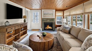 A living room with a fireplace, a television, a sofa, and a coffee table.